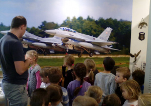 Dzieci oglądają zbiory związane z lotnictwem wojskowym na ziemi łaskiej.